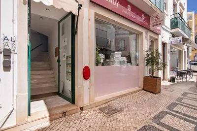a store front with a window with a potted plant inside at Faro Downtown Suites - Vila Adentro in Faro
