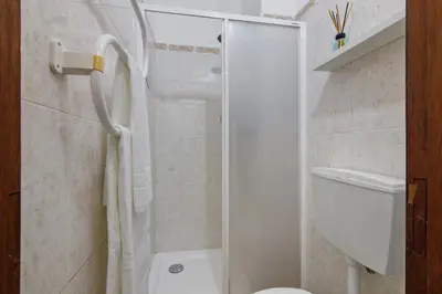 a bathroom with a toilet and a sink and a shower at Faro Downtown Suites - Vila Adentro in Faro