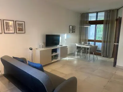 a living room with a couch and a tv and a table at Casa Altair in Quarteira