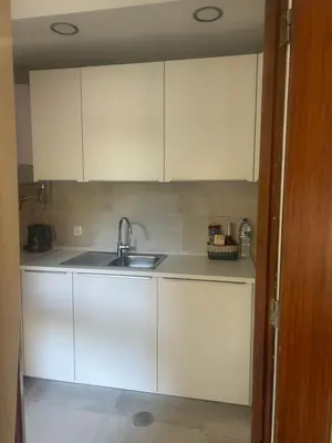 a kitchen with white cabinets and a sink at Casa Altair in Quarteira