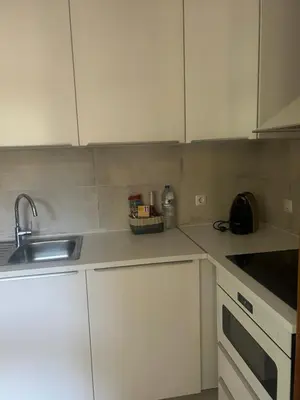 a kitchen with white cabinets and a sink at Casa Altair in Quarteira