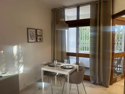 a white table and chairs in a room with a window at Casa Altair in Quarteira