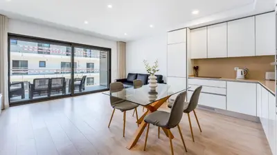 a kitchen and dining room with a glass table and chairs at Elegant 2BDR Apartment in Quarteira by Lovelystay in Quarteira