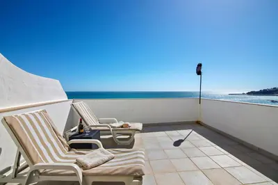 two chairs on a balcony with a view of the ocean at Casa Vista Mar in Albufeira