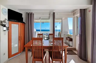 a dining room with a table and chairs and the ocean at Casa Vista Mar in Albufeira