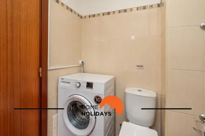 a bathroom with a washing machine next to a toilet at #286 Avenida de Ceuta - Alsol by Home Holidays in Quarteira