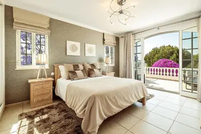 a bedroom with a large bed and a large window at Lovely Very Private Villa with Beautiful Gardens in Guia