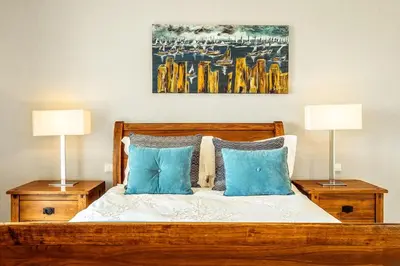 a bedroom with a wooden bed with blue pillows at Lovely Very Private Villa with Beautiful Gardens in Guia