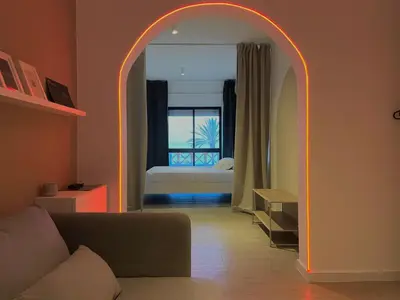 a living room with an arch with a bed in the background at Sunflower12 - Apartamento à beira-mar - Seaview in Quarteira