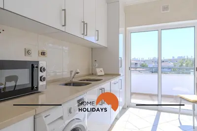 a kitchen with a microwave and a stove top oven at #320 Quinta da Correeira 55 by Home Holidays in Vale de Pedras
