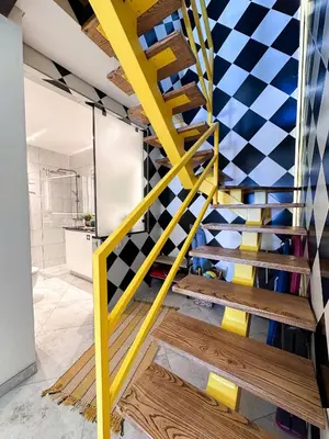 a yellow staircase in a bathroom with a checkered wall at Luxury Beach House - Casa do Farol by BeCherish in Albufeira