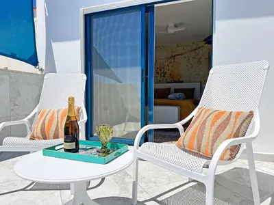 two chairs and a table with a bottle of wine at Luxury Beach House - Casa do Farol by BeCherish in Albufeira