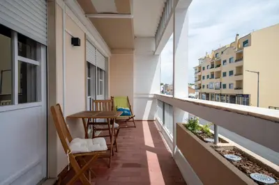 a balcony with chairs and a table on a building at BeGuest Dream House in Loulé