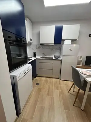 a small kitchen with white appliances and a table at Charmoso T1 Varandas de Malpique in Albufeira