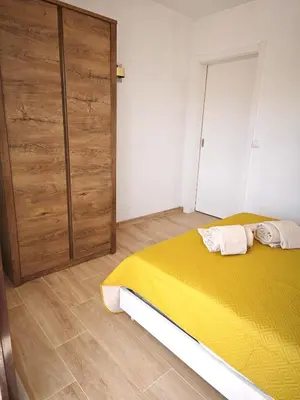 a bedroom with a yellow bed and a closet at Charmoso T1 Varandas de Malpique in Albufeira