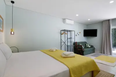 a bedroom with a bed with a yellow blanket on it at Excelente Studio in Loulé