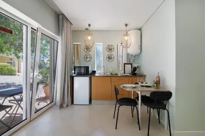 a kitchen and dining room with a table and chairs at Excelente Studio in Loulé