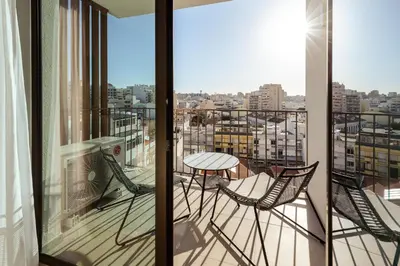 a balcony with two chairs and a table at The View at The Downtown Faro in Faro