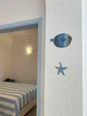 a bedroom with a blue table and a window at Casa da Praia em Olhos de Água a 50 metros da Praia in Olhos de Água