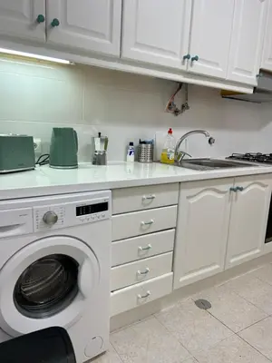 a kitchen with a washing machine with two mugs on it at Casa da Praia em Olhos de Água a 50 metros da Praia in Olhos de Água
