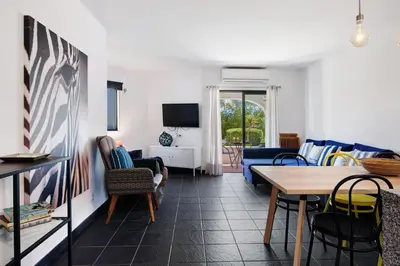a living room with a blue couch and a table at Kyara House in Albufeira