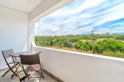 a balcony with a table and chairs and a large window at A Casa da Ana - By Algarkasa in Albufeira