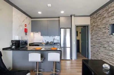 a kitchen with a counter with two stools at Mar à Vista in Albufeira