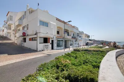 a building on a street next to the ocean at Mar à Vista in Albufeira