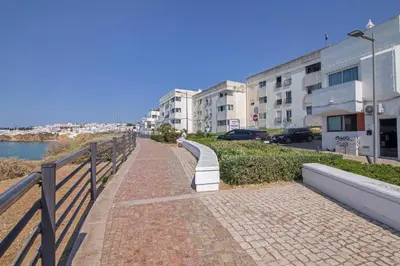 a brick sidewalk next to a fence next to a building at Mar à Vista in Albufeira
