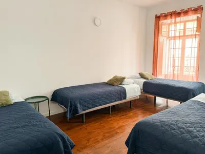 a room with three beds and a window at Sao Pedro Guest House in Faro