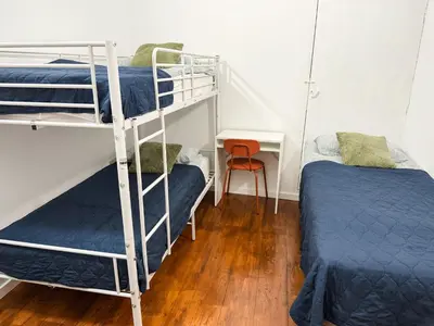 a bedroom with two bunk beds and a desk at Sao Pedro Guest House in Faro