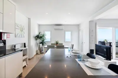 a kitchen and living room with a large dining table at Paraná in Quarteira