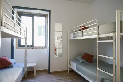 a small room with bunk beds and a window at Guest House Mercado in Faro