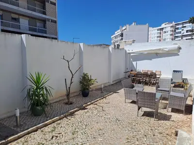 a patio with chairs and plants and a fence at Guest House Mercado in Faro