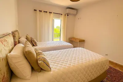 a bedroom with two beds and a window at NEW! Casa do Praia Almancil in Almancil