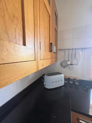 a kitchen with wooden cabinets and a toaster on a counter at NEW! Casa do Praia Almancil in Almancil