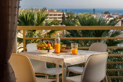 a table with a bowl of fruit and two glasses of orange juice at Ver o Mar in Albufeira