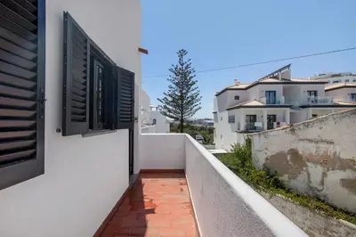 a white balcony with a table and chairs at Casa Mar Sol E Sossego in Albufeira