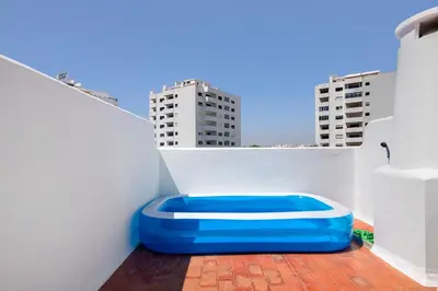a blue seat on a balcony with buildings in the background at Casa Mar Sol E Sossego in Albufeira