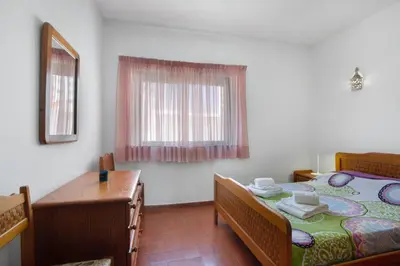 a bedroom with a bed with a wooden bed frame at Casa Mar Sol E Sossego in Albufeira