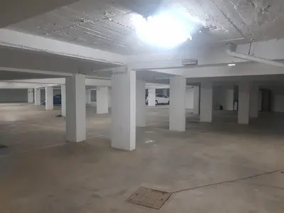 an empty parking lot with white columns in a parking garage at Central 2 Beedroms Old Tow Apartment in Albufeira