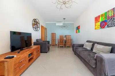 a living room with a couch and a tv at BnB Homes Eco Apartment with Terrace, 2 Swimming pools & Tennis court in Albufeira