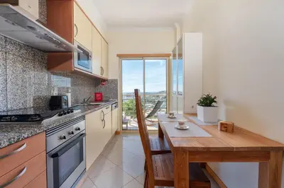 a group of lawn chairs sitting next to a swimming pool at BnB Homes Eco Apartment with Terrace, 2 Swimming pools & Tennis court in Albufeira