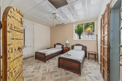 a bedroom with two beds and a window at Villa Saromani in Branqueira