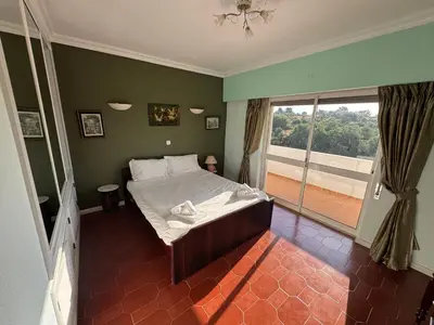 a bedroom with a bed and a large window at Villa Saromani in Branqueira