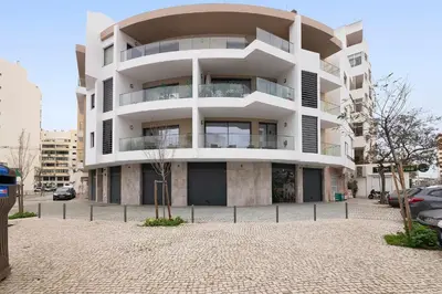 a large white building on a city street at São Luís Faro Apartment - Algarve in Faro