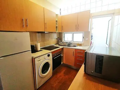 a kitchen with a refrigerator and a washer and dryer at Casa do Pino in Faro
