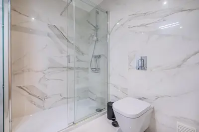 a white bathroom with a shower and a toilet at Prime Luxury Apartment by Atlantic Places in Albufeira