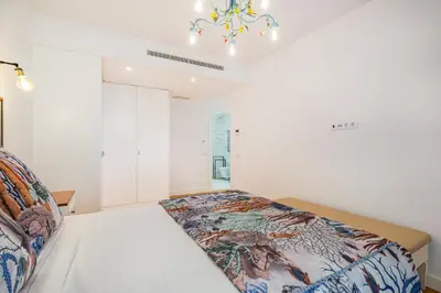 a bedroom with a bed and a chandelier at Prime Luxury Apartment by Atlantic Places in Albufeira