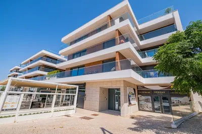 a tall white building with a tree in front of it at Prime Luxury Apartment by Atlantic Places in Albufeira